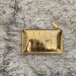 Reflective gold Estée Lauder small makeup bag